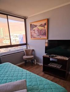 a bedroom with a bed and a television and a window at Departamento en Playa Brava Iquique 1 dormitorio 1 baño in Iquique