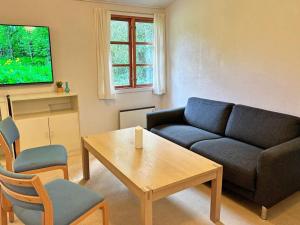 een woonkamer met een bank en een tafel bij Holiday home Aakirkeby VI in Vester Sømarken