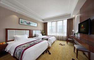 a hotel room with two beds and a television at Honglilai Hotel in Bao'an