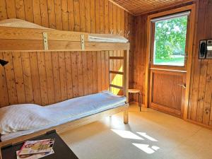 a bedroom with two bunk beds and a window at Holiday home Aakirkeby VI in Vester Sømarken