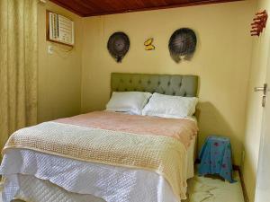 - un lit dans une chambre avec deux chapeaux sur le mur dans l'établissement Visual do Abraão, à Angra dos Reis