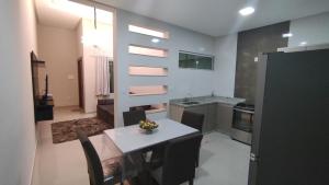 uma cozinha com uma mesa e uma sala de jantar em Casa TOP 1 Suite e 2 Quartos todos com Ar Condicionado em Guanambi