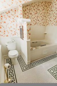 a bathroom with a toilet and a bath tub at The Rochester Inn in Sheboygan Falls