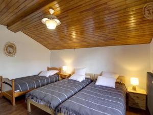 two beds in a room with a wooden ceiling at Gîte Chalmazel-Jeansagnière, 6 pièces, 12 personnes - FR-1-496-249 in Chalmazel Jeansagniere