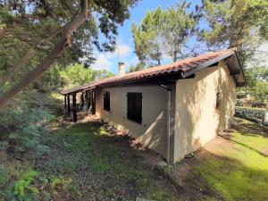 mały biały budynek z czerwonym dachem w obiekcie Maison familiale avec jardin, près de l'océan dans un quartier calme - FR-1-239-820 w mieście Labenne