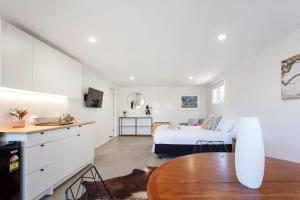 een slaapkamer met een bed en een keuken met een tafel bij Studio Escape in Hamilton Hill