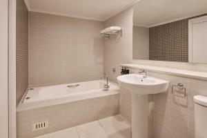 勒弗戴尔Rydges Resort Hunter Valley的带水槽、浴缸和水槽的浴室