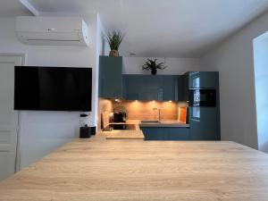 une cuisine avec des armoires bleues et un comptoir dans l'établissement Appartement lumineux 3 pièces près des Halles et de la plage, wifi, clim, parkings proches - FR-1-239-910, à Saint-Jean-de-Luz