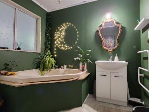 a bathroom with a tub and a sink and a mirror at The Treehut in Island Bay