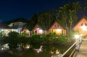 a row of cottages at night at Best House Resort in Ban Pak Ba Ra