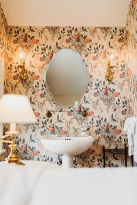 ein Badezimmer mit einem Spiegel und einem Waschbecken in der Unterkunft The Rochester Inn in Sheboygan Falls
