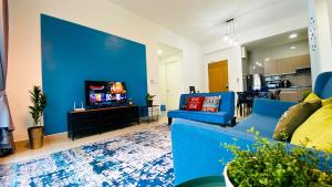 a living room with a blue couch and a tv at The Icon4 Condo in IOI City Mall Putrajaya, Netflix in Putrajaya