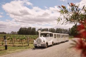 an old white bus driving down a road at Rydges Resort Hunter Valley in Lovedale