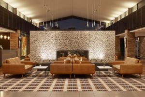 a lobby with brown couches and a fireplace at Rydges Resort Hunter Valley in Lovedale