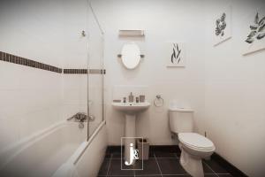 La salle de bains est pourvue de toilettes, d'un lavabo et d'une douche. dans l'établissement The Port Solent City Apartment - Southampton, Portsmouth, à Southampton