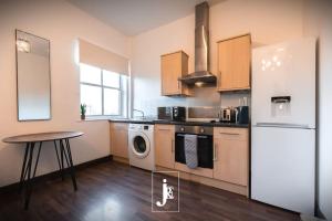 a kitchen with a refrigerator and a table in it at The Port Solent City Apartment - Southampton, Portsmouth in Southampton