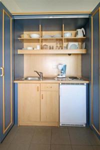 eine kleine Küche mit Spüle und Geschirrspüler in der Unterkunft Yachthafenresidenz - Wohnung 9304 / 888 in Kühlungsborn