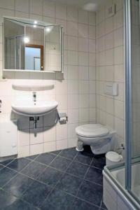 a bathroom with a sink and a toilet and a mirror at Yachthafenresidenz-Wohnung-9304-888 in Kühlungsborn