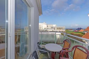 a balcony with a table and chairs and a view of the ocean at Yachthafenresidenz-Wohnung-6303-773 in Kühlungsborn