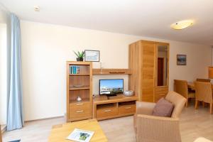 a living room with a television and a table at Yachthafenresidenz-Wohnung-6303-773 in Kühlungsborn