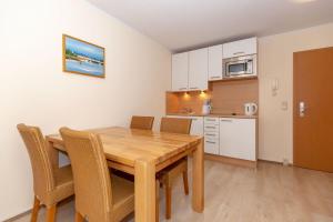 a kitchen and dining room with a wooden table and chairs at Yachthafenresidenz-Wohnung-6303-773 in Kühlungsborn