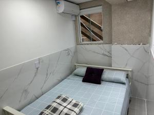 a small bed in a room with a window at Moradas Desterro, próximo ao aeroporto 03 in Florianópolis
