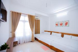 1 dormitorio con 2 camas y ventana en Lavie House 3 - Số 14 Nguyễn Hiền en Vung Tau