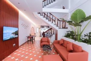 sala de estar con sofá rojo y escaleras en Lavie House 3 - Số 14 Nguyễn Hiền en Vung Tau