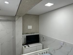 a room with a tv on a wall at Moradas Desterro, próximo ao aeroporto 03 in Florianópolis