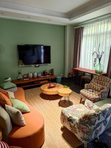 a living room with two couches and a flat screen tv at Green Stay in Hualien City