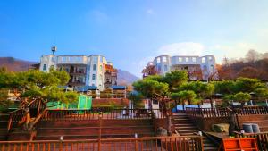 eine Gruppe von Gebäuden mit Treppen und Bäumen davor in der Unterkunft Travely Hotel Gapyeong in Gapyeong