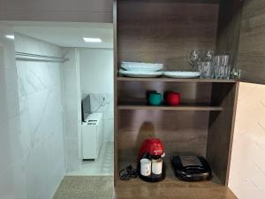 a small kitchen with a red appliance on a shelf at Moradas Desterro, próximo ao aeroporto 03 in Florianópolis