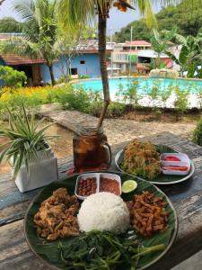 a plate of food on a table with rice and meat at Wae Molas Hotel in Labuan Bajo