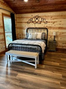a bedroom with a bed in a log cabin at Livin on the Edge Cabin in Albert Pike, Brand New! in Caddo Gap