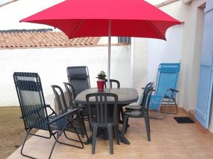 La Pironnière的住宿－Maison Les Sables-d'Olonne, 3 pièces, 6 personnes - FR-1-92-743，庭院里配有桌椅和红伞