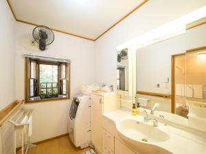 y baño con lavabo y lavadora. en スイートヴィラ NASU四季リゾート, en Nasu