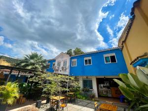 um edifício azul com mesas e cadeiras num pátio em OUR HOME SAN ANTONIO em Cali