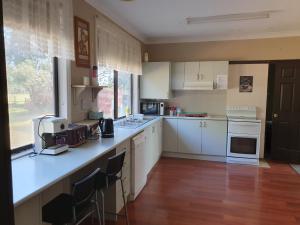 a kitchen with white cabinets and a large window at Three bedroom double lounge large house, sleeps 6 