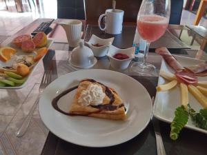 a table with a plate of food and a glass of wine at Atavai Hotel Rapa Nui in Hanga Roa