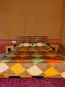 Un dormitorio con una colcha colorida en una cama en Empyrean Tarry, en Igatpuri