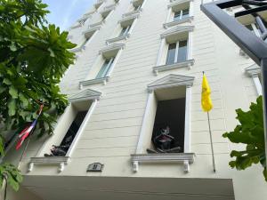 a white building with two statues in a window at Chez Moi Bangkok Private Executive Residence Sukhumvit 26 in Klong Toi