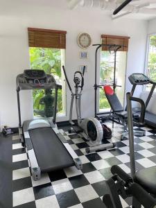 a gym with a treadmill and exercise equipment on a checkered floor at Chez Moi Bangkok Private Executive Residence Sukhumvit 26 in Klong Toi