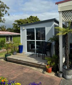 a tiny house with a deck with a table at Raglan Seaview Cabin in Raglan