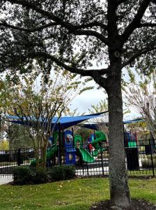a playground in a park with a blue and green slide at Parkside at Avalon Park in Orlando