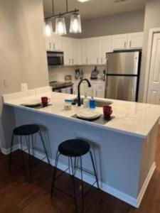 a kitchen with a counter with stools and a sink at Parkside at Avalon Park in Orlando