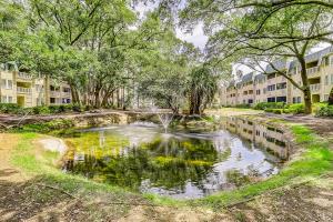 Un estanque en un parque con árboles y edificios. en Spa on Port Royal Sound #3309, en Hilton Head Island