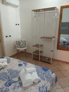 a bedroom with a bed with towels on it at ACasammare Apartment in Marsala +21 photos