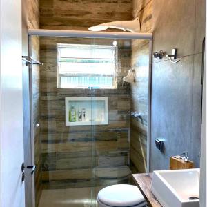 uma casa de banho com um chuveiro, um WC e um lavatório. em Casinha da Rena em Cambury em São Sebastião