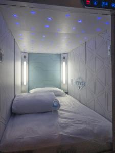 a bed in a room with lights on the ceiling at Izzzleep Aeropuerto Terminal 1 in Mexico City