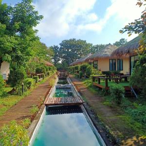 a canal in front of a house with water in it at Aurora Resort Chiangdao in Chiang Dao